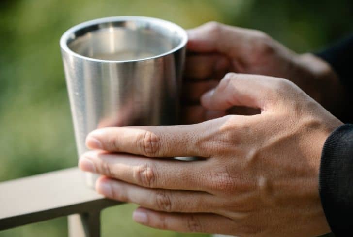 person-holding-steel-cup