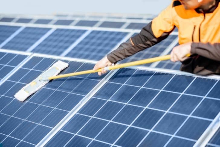 man-cleaning-solar-panels