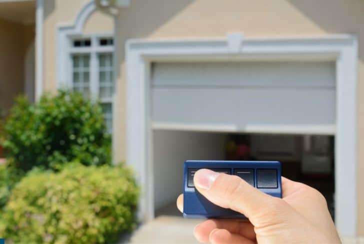 man-pressing-button-of-garage-door-opener