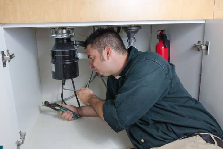 man-repairing-garbage-disposal