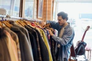 man-checking-clothes-in-thrift-store